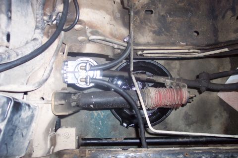 1995 Ford Bronco - Close-up view of a fuel filter and part of the steering linkage, possibly from a 1995 Ford Bronco.