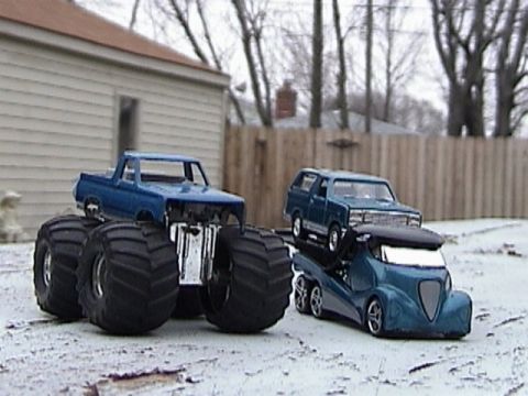 1979 Ford Bronco - Three toy vehicles, including a monster truck and an SUV, are displayed outdoors in the snow.