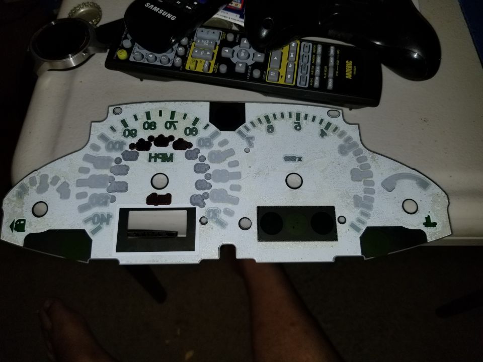 Back side of instrument cluster faceplate showing gauge circuit board cutouts
