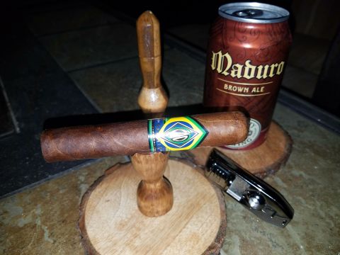 2018 Ford Bronco - A cigar rests on a wooden stand, accompanied by a can of Maduro Brown Ale and a cigar cutter, suggesting a moment of relaxation.