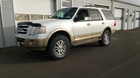 1996 Ford Bronco - This Ford Expedition SUV is parked outside a commercial building.