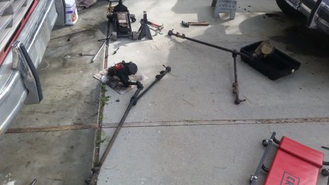 1985 Ford Bronco - Steering linkage components, including the gearbox and tie rods, are visible on the ground.
