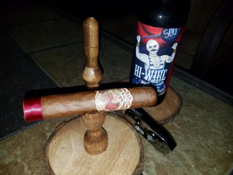 2018 Ford Bronco - A cigar rests on a wooden holder, accompanied by a bottle of Hi-Wire beer and a lighter on a tiled surface.