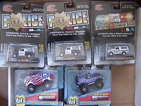 1979 Ford Bronco - A collection of boxed 1/64 scale toy vehicles, including police and fire rescue models, are displayed.
