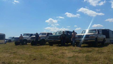 1988 Ford Bronco - Multiple Ford trucks and SUVs gathered in an open field on a sunny day.