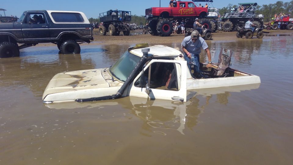 White pickup truck stuck in mud with snorkel, side view