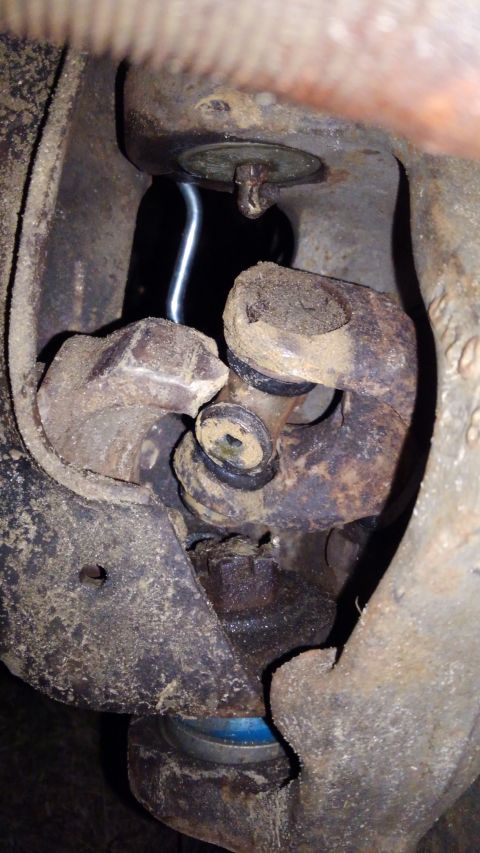 1988 Ford Bronco - This image shows a close-up view of a vehicle's u-joint and surrounding suspension components, covered in dirt and rust.