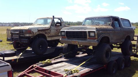 1988 Ford Bronco - Two lifted Ford trucks are transported on trailers, one is a Bronco, the other a pickup.