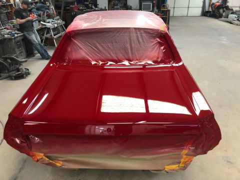 1968 Mercury Cougar - A red car is being prepped for paint in a garage, with plastic covering the windows and rear.