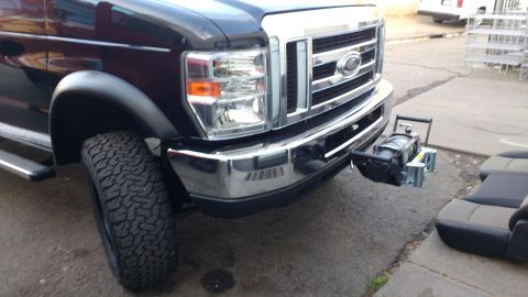 1996 Ford Bronco - A dark Ford E-Series van is shown from the front, a winch attached to its bumper.