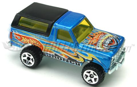 1979 Ford Bronco - A blue Hot Wheels Ford Bronco casting in three-quarter front view against a white background, wearing orange and yellow flame graphics, the…