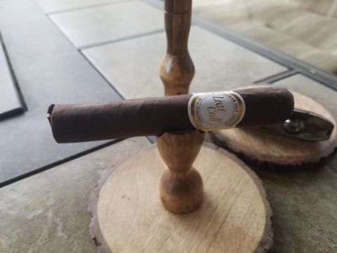 2018 Ford Bronco - A cigar rests on a wooden stand, its band labeled 'Last Call', with a lighter visible in the background.