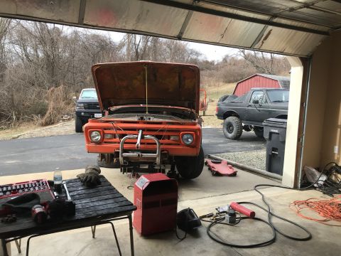 1961 Ford F-350 - Front view of an orange 1961 Ford F-350 undergoing work in a garage.