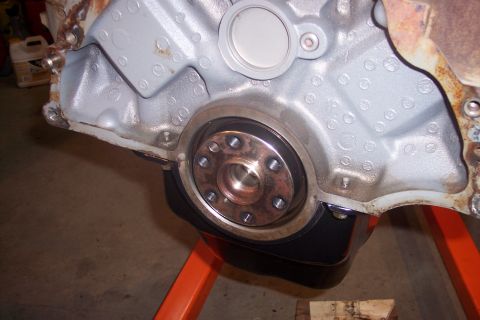 1995 Ford Bronco - Close-up of an engine block's crankshaft seal and oil pan, mounted on an orange engine stand.