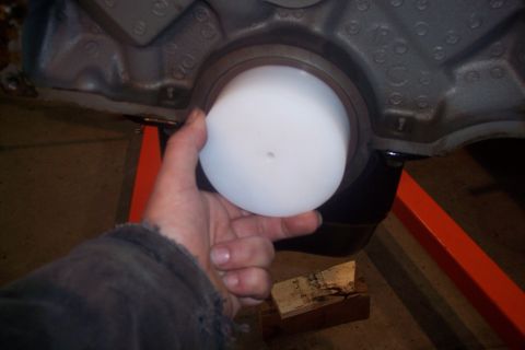 1995 Ford Bronco - A hand holds a white plug, about to insert it into an engine block. The registry claims this is a 1995 Ford Bronco.