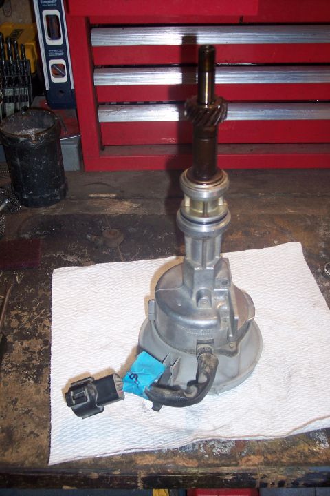 1995 Ford Bronco - A vehicle distributor part is shown on a workbench, with tools and a toolbox visible in the background.