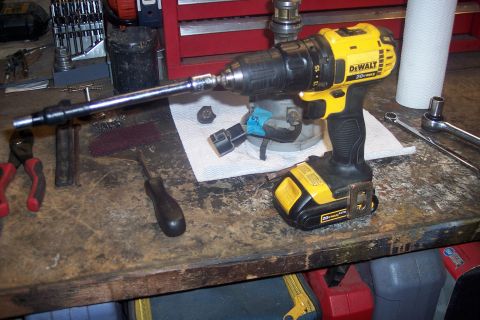 1995 Ford Bronco - A DeWalt drill is set up with a long extension, ready for use on engine components.