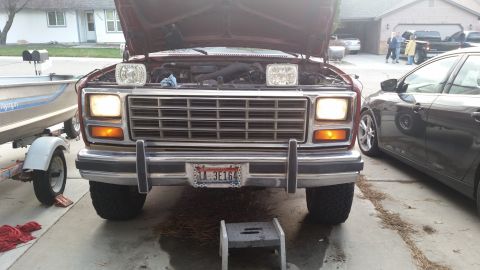 1985 Ford Bronco - This red Ford Bronco, likely from the early 1980s, is parked with its hood up, revealing the engine compartment.