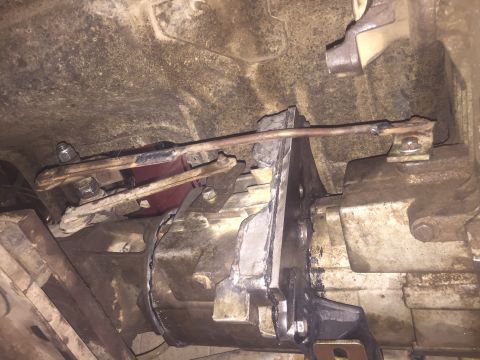 1984 Ford Bronco - Close-up view of the transfer case linkage assembly, showing mechanical components and connections.
