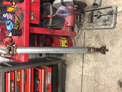 1984 Ford Bronco - Driveshaft and various tools in a workshop setting.