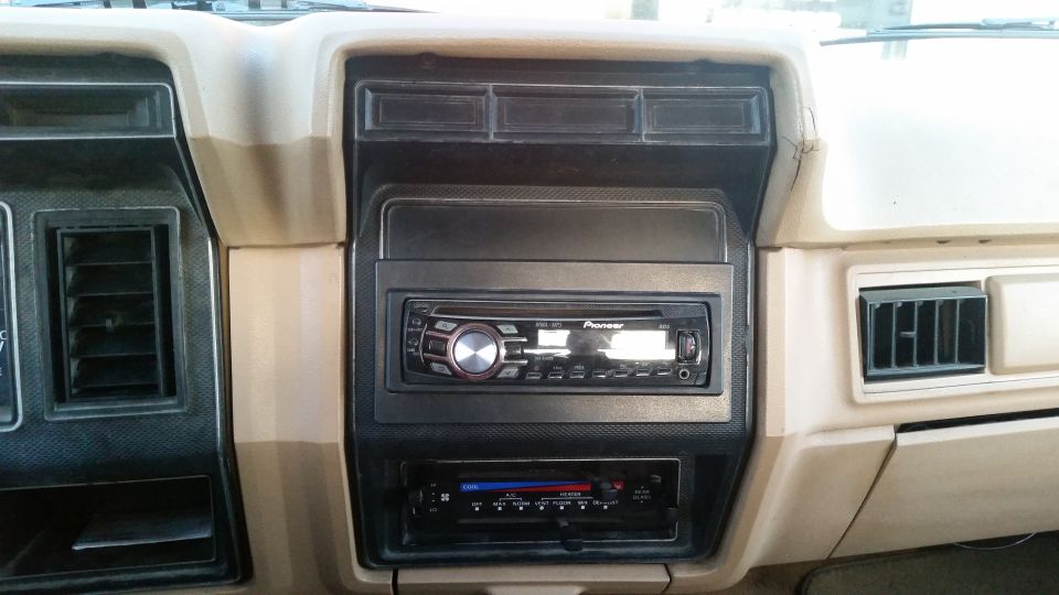 Car dashboard interior with Pioneer stereo and air vents. Beige and black trim