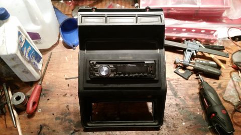 1985 Ford Bronco - A dashboard speaker install kit is shown with a Pioneer stereo and various tools laid out on a wooden surface.
