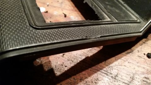1985 Ford Bronco - Close-up of a dark, textured dashboard trim piece with a cutout, likely for a speaker or gauge.