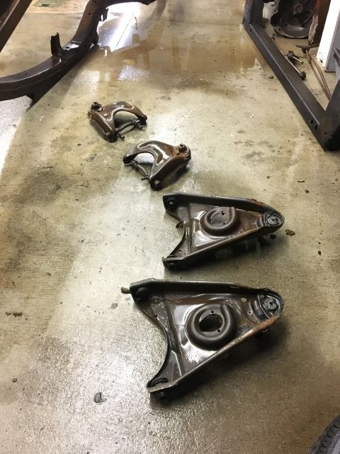 1962 Ford Galaxie - Car suspension control arms are shown on a concrete floor, possibly during restoration.