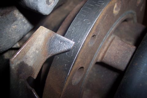 1995 Ford Bronco - A metal pointer aligns with timing marks on a pulley or flywheel in an engine bay.