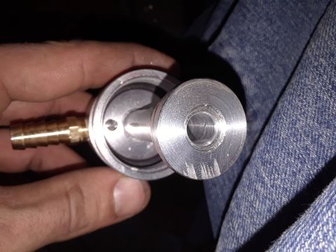 1994 Ford Bronco - Close-up of a metal fitting with a brass barb, held by a person's hand.