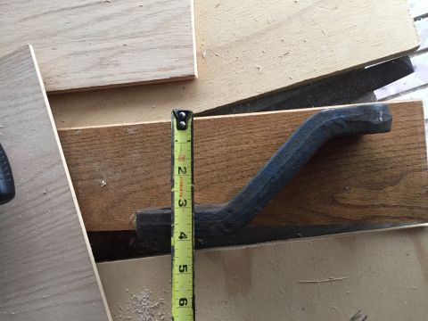 1967 Ford Custom Wagon - A metal part is measured with a tape measure against wooden planks.