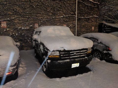 1995 Ford Bronco - A black Ford Bronco is parked outside in the snow, with a license plate visible.