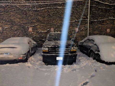 1995 Ford Bronco - A black 1995 Ford Bronco is parked in the snow between two other vehicles.