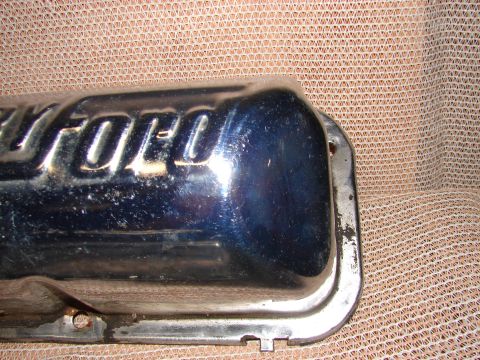 1973 Ford Ranchero - A chrome valve cover with the Ford logo is shown against a textured background.