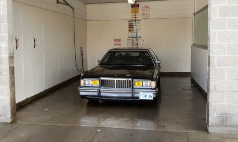 1985 Mercury Grand Marquis - Front view of a black 1985 Mercury Grand Marquis in a car wash.