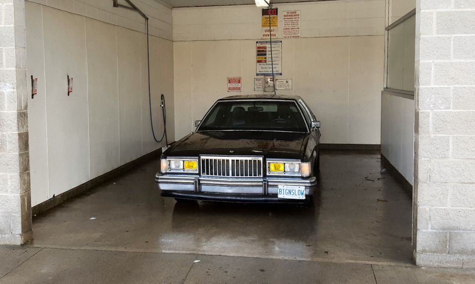 1985 Mercury Grand Marquis parked inside a self-service car wash bay