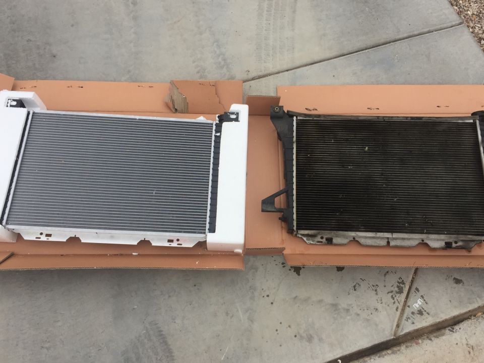 New radiator in box next to old, dirty radiator