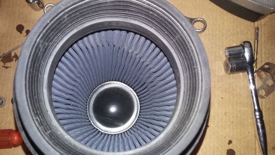 Close-up of a blue air filter with a socket wrench nearby