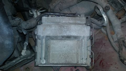 2000 Pontiac Grand Prix - Engine control module with visible part numbers and wiring harnesses.