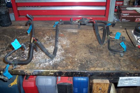 1995 Ford Bronco - Wiring harness components are laid out on a cluttered workbench.