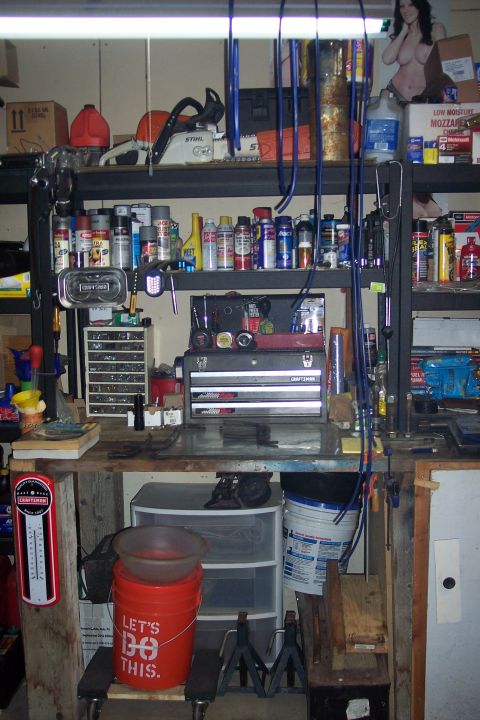 1995 Ford Bronco - Workbench in a garage filled with various tools, supplies, and storage containers.