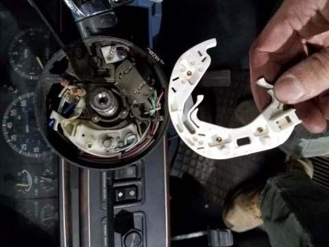 1987 Ford Bronco - The interior of a vehicle's steering column is shown disassembled, revealing wiring and components.