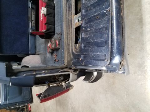 1987 Ford Bronco - The rear interior of a 1987 Ford Bronco shows a Husky tool bag and a detached taillight assembly.