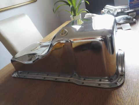1974 Ford Ranchero - Shiny chrome oil pan sitting on a wooden surface.
