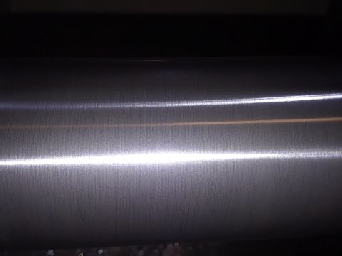 1994 Ford Bronco - A close-up view of a metallic surface with distinct horizontal lines and bright light reflections.