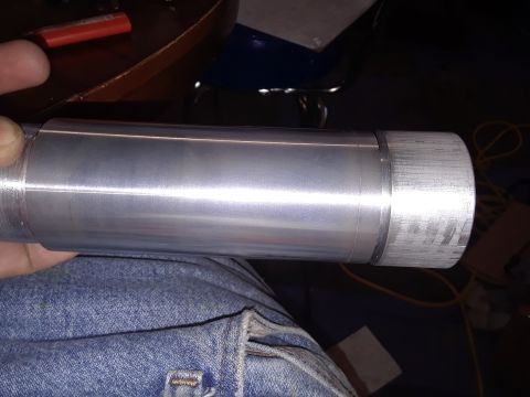 1994 Ford Bronco - A close-up view of a metal cylinder with a knurled end, held by a person wearing denim.