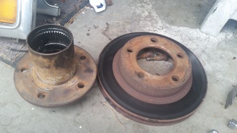 1985 Ford Bronco - A rusty brake rotor and hub assembly are shown, likely for a vehicle part replacement.