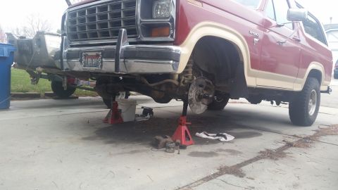 1985 Ford Bronco - Ford Bronco undergoing brake maintenance with front wheels removed.