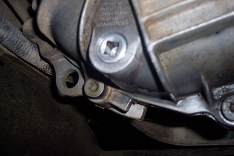 1995 Ford Bronco - Transmission drain plug detail, showing the square drive opening and surrounding metal casing.