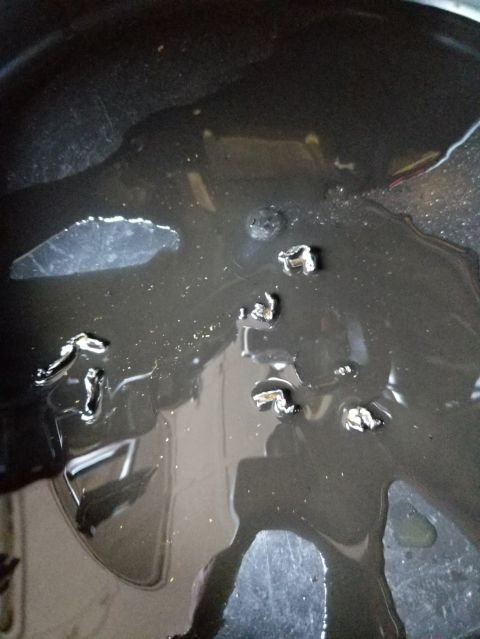 2014 Harley-Davidson FXDWGI Wide Glide - Metal fragments are visible in the dark, viscous fluid, suggesting potential engine wear or damage.